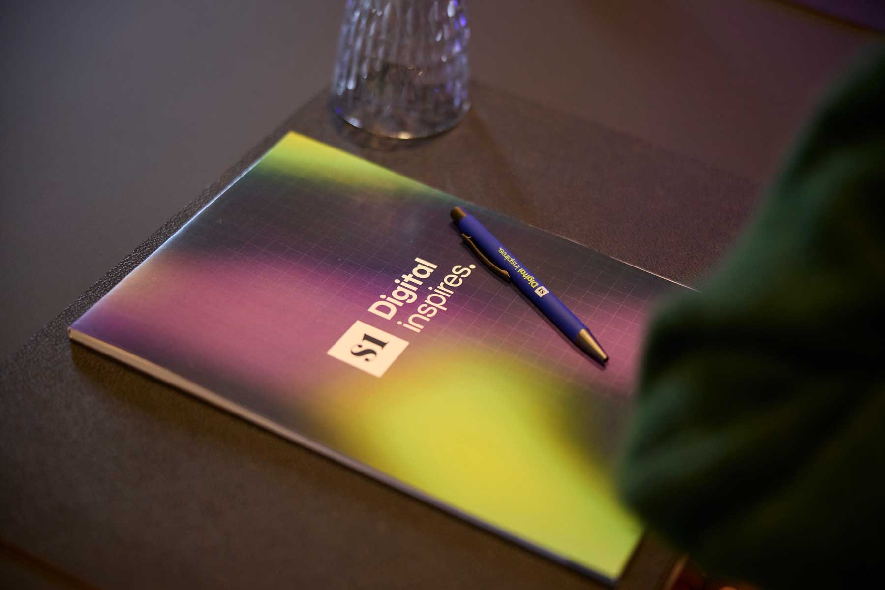 Notitieboek en pen met S1 Inspires-branding op een conferentietafel.